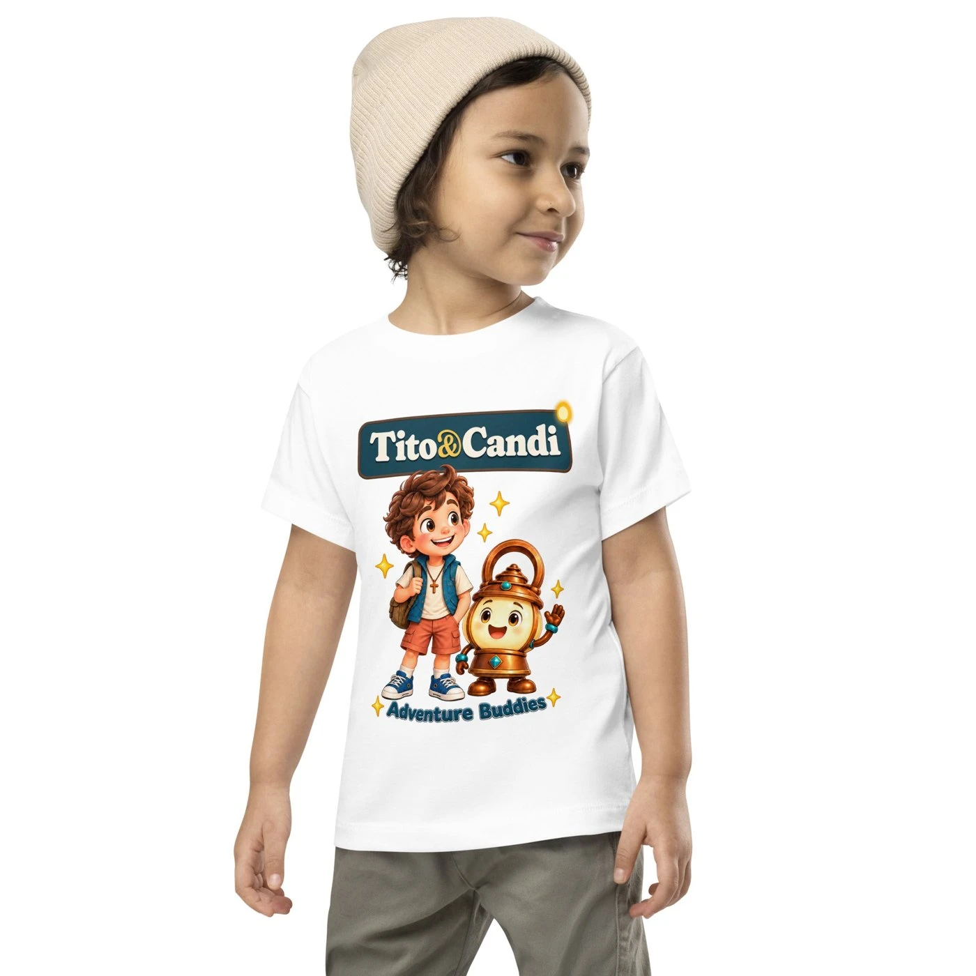 Toddler in a white T-shirt with Tito and Candi side by side and the words Adventure Buddies